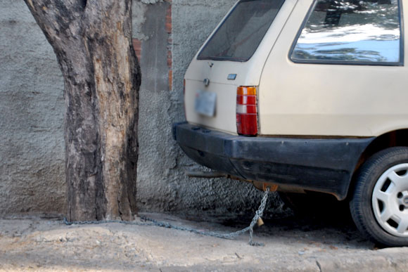 Carro está preso a árvore com uma corrente / Foto: Marcelo Paiva