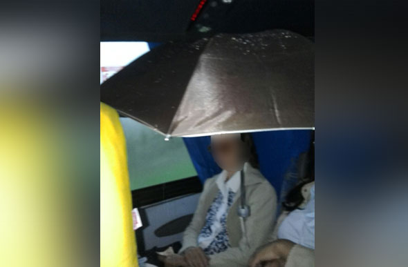Idosa se protege de goteira com guarda-chuva dentro de ônibus rodoviário / Foto: portalmatozinhos.com