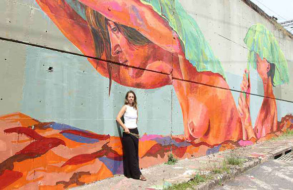 A artista Priscila Amoni diante do painel pintado em paredão de linha férrea em BH: 'Temos que renascer dessa lama. Não dá para afundar nela' (foto: Jair Amaral/EM/D.A PRESS)