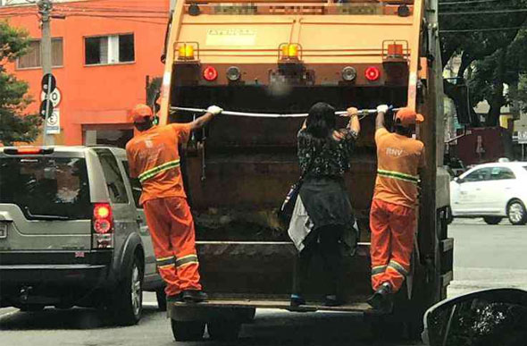 Foto: Michael Warshaw/ Mulher pega carona em caminhão de lixo