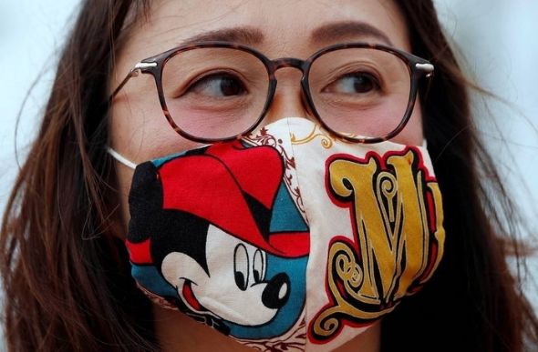 Visitante usa uma máscara com desenho do Mickey na reabertura da Disneyland de Tóquio — Foto: ISSEI KATO / REUTERS