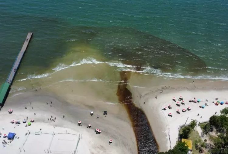 Corrente de água poluída do rio do Brás, em Canasvieiras, desaguando em praia de Florianópolis - SC.